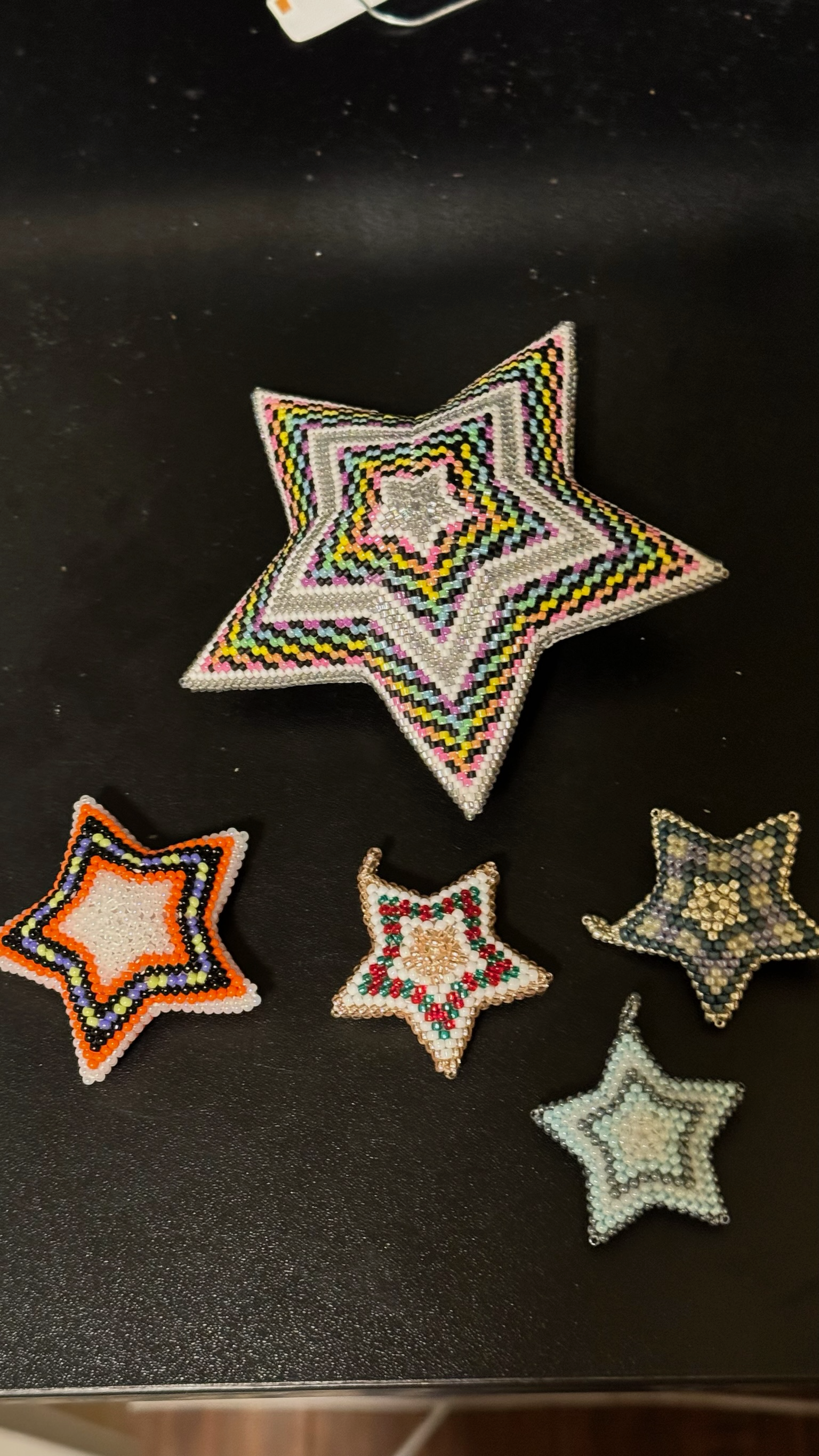 Collection of beaded star ornaments in various sizes with colorful chevron patterns